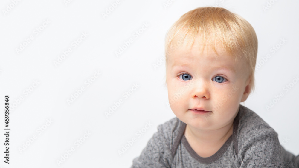 Infant child baby boy in gray shirt laughs happy looking at the camera isolated on a white background. Childcare and upbringing concept. Infant child baby boy in gray shirt laughs happy looking at the camera isolated on a white background. Childcare and upbringing concept.