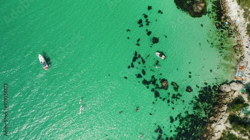 Aerial view of Baunty beach on cape Fiolent in Balaklava, Sevastopol. Crimea. Pleasure trip boats in azure sea water on sunny summer day. Travel and tourism concept footage photo