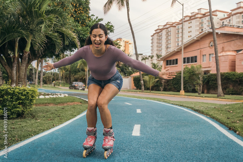 Hispanic young adult woman rollerskating and smiling with her arms open
