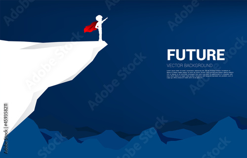 Silhouette of boy in superhero suit point from the cliff. Concept of education start and future of children.