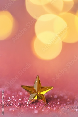 Wallpaper phone .New Year and Christmas background. gold star in pink glitter on shining golden bokeh background.Beautiful festive background in rose gold tones.Shining texture.