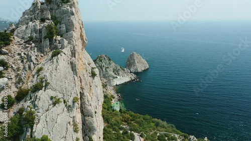 Aerial fly above Mountain Koshka of Simeiz with Diva rock in background. Crimea mountain and black sea coastal seascape landscape on sunny summer day. photo