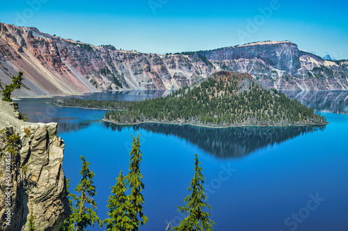 Blue lake in the mountains with large volcanic cinder cone island.