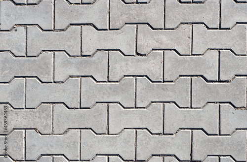 The texture of gray paving slabs in the shape of a reel with scuffs.