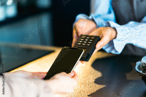 カフェ（飲食店）でスマホ決済をする女性の手元