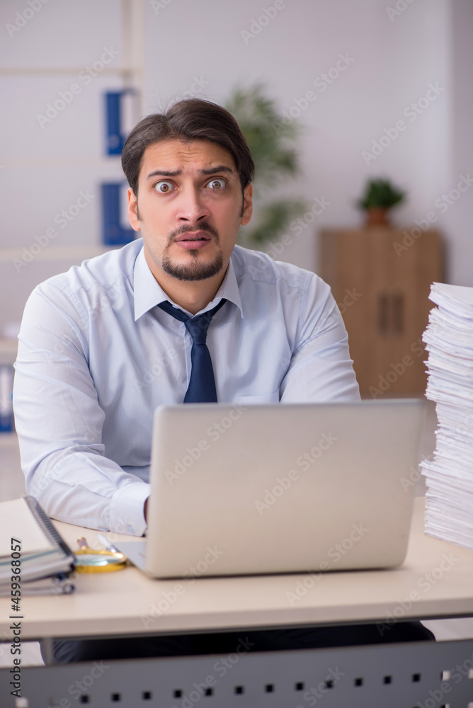 Young businessman employee unhappy with excessive work in the of Young businessman employee unhappy with excessive work in the of