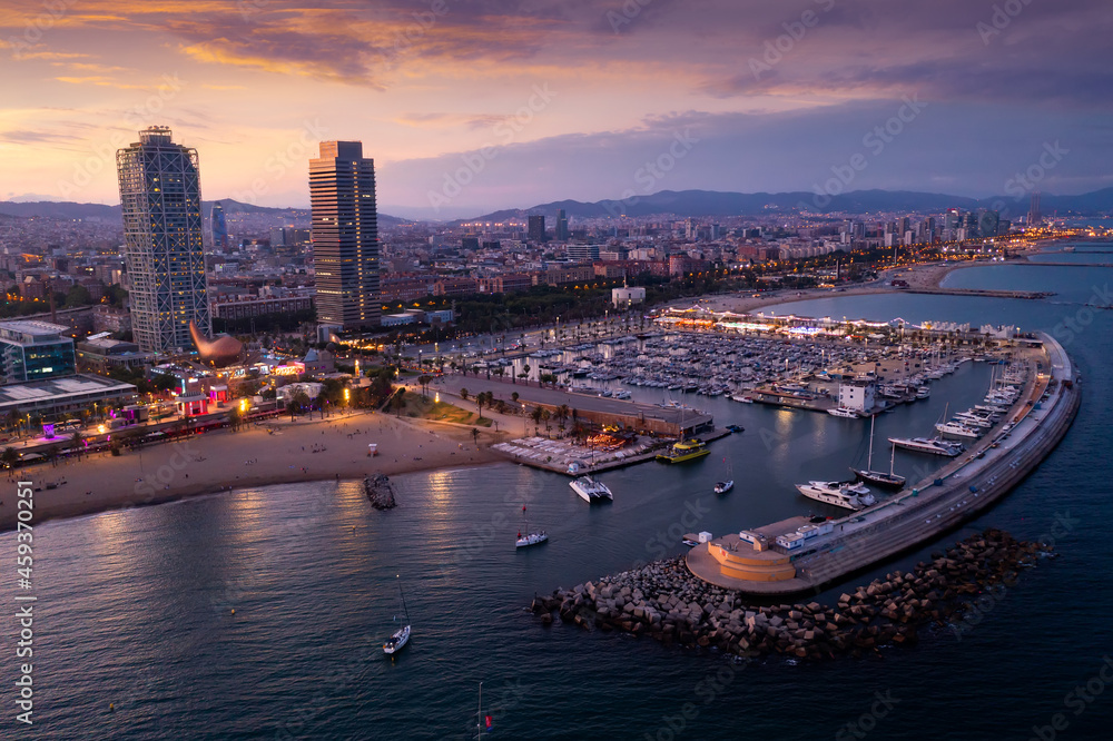 Scenic aerial panoramic view of modern Barcelona cityscape on Mediterranean coast with marina at summer twilight, Spain