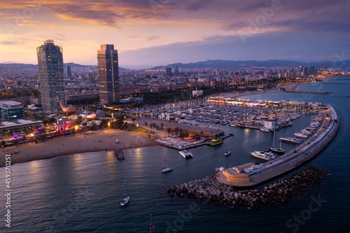 Scenic aerial panoramic view of modern Barcelona cityscape on Mediterranean coast with marina at summer twilight, Spain