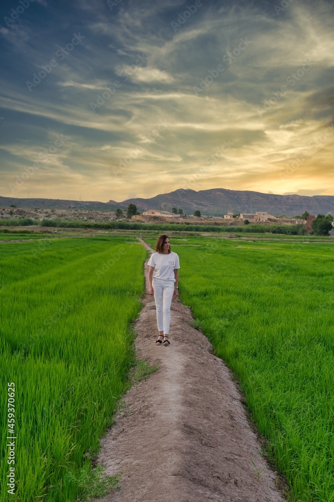 Obraz premium woman cleaning by landscape of rice fields.