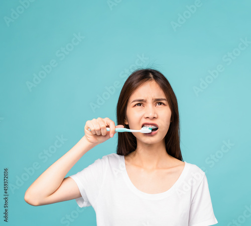 Asian woman brushing teeth on a blue background  Concept oral hygiene and health care.