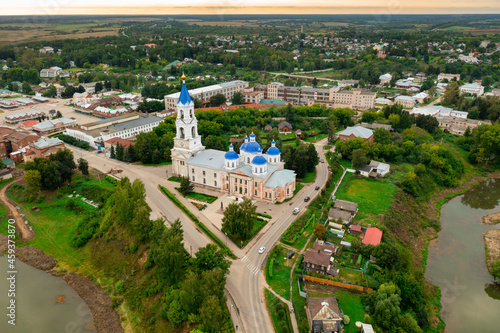 Aerial view of historic Russian town of Kashin on banks of Kashinka River overlooking ancient Resurrection Cathedral with high bell tower on summer day, Tver region photo