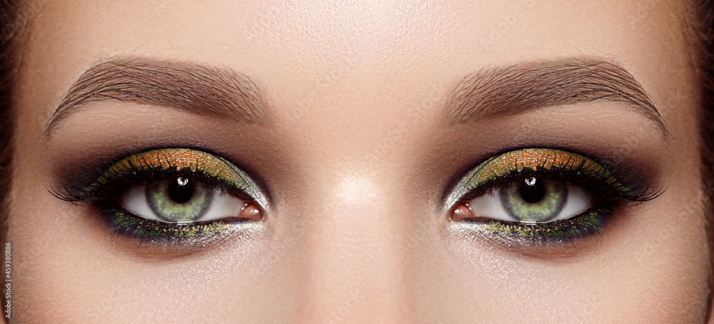 Closeup Macro of Woman Face with Green Eyes Make-up. Fashion Celebrate Makeup, Glowy Clean Skin, perfect Shapes of Brows Closeup Macro of Woman Face with Green Eyes Make-up. Fashion Celebrate Makeup, Glowy Clean Skin, perfect Shapes of Brows