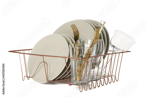 Set of clean dishes in drainer on white background photo