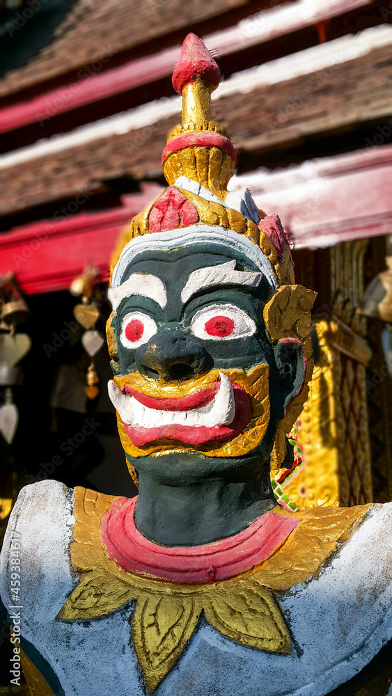 Close-up view of Thai statue in the temple against blue sky.