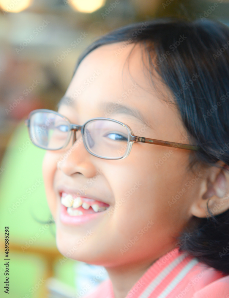 A smiling girl poses in a restaurant A smiling girl poses in a restaurant