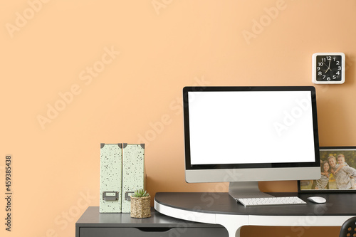 Modern workplace with computer near color wall photo