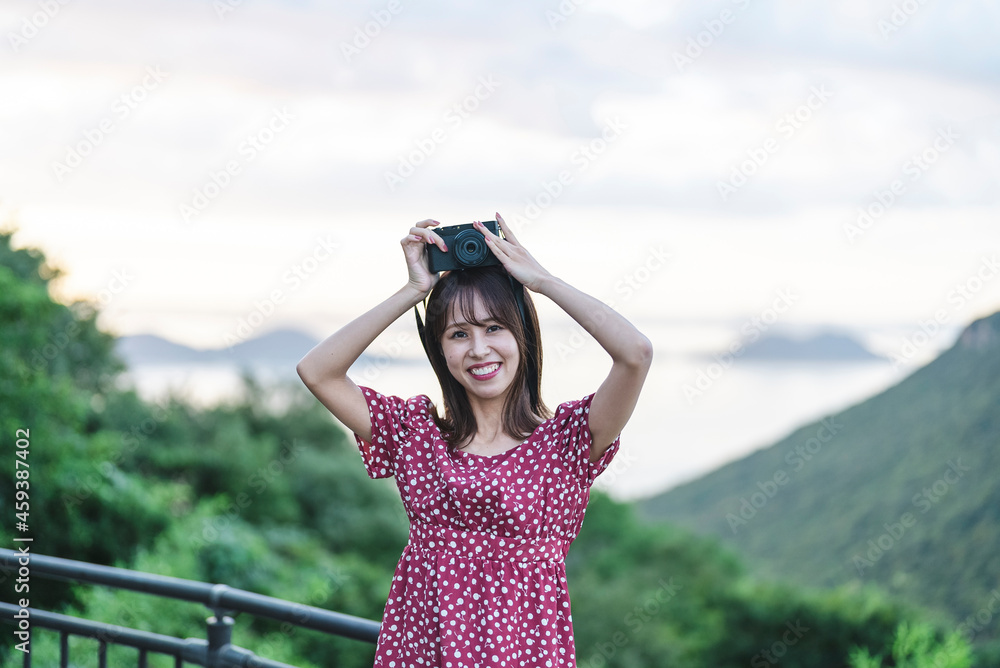 夕暮れの観光地で撮影をするカメラ女子
