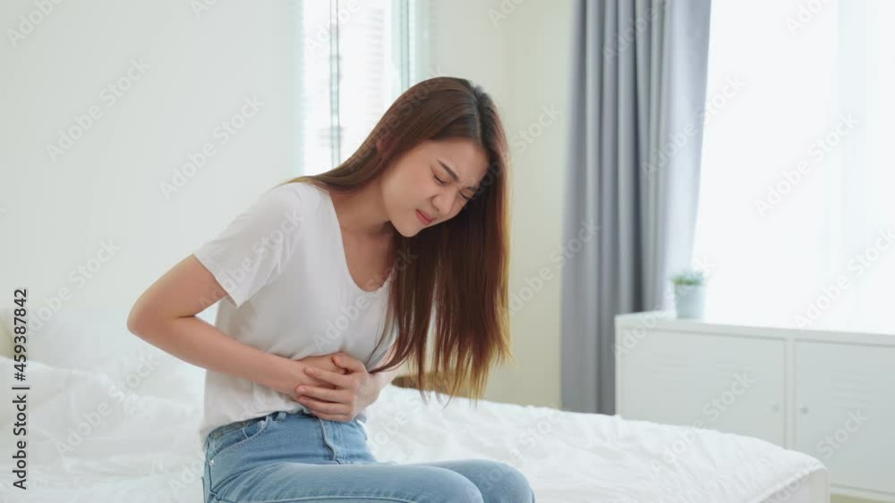 Asian beautiful sick girl suffering from hurt stomachache in bedroom. Asian beautiful sick girl suffering from hurt stomachache in bedroom.