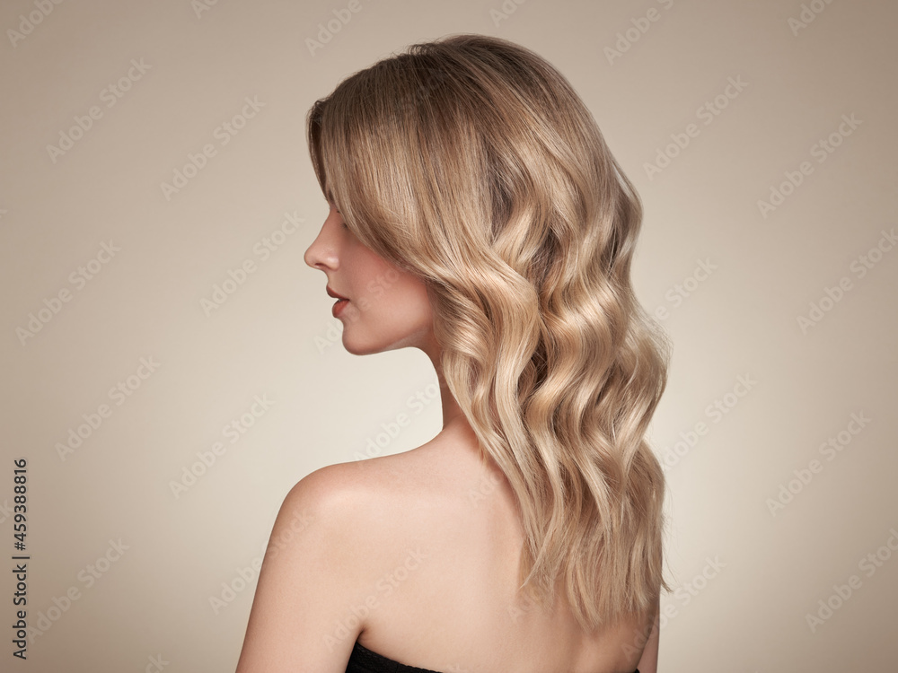 Blonde woman with long and shiny curly hair. Beautiful model girl with curly hairstyle. Care and beauty hair products Blonde woman with long and shiny curly hair. Beautiful model girl with curly hairstyle. Care and beauty hair products