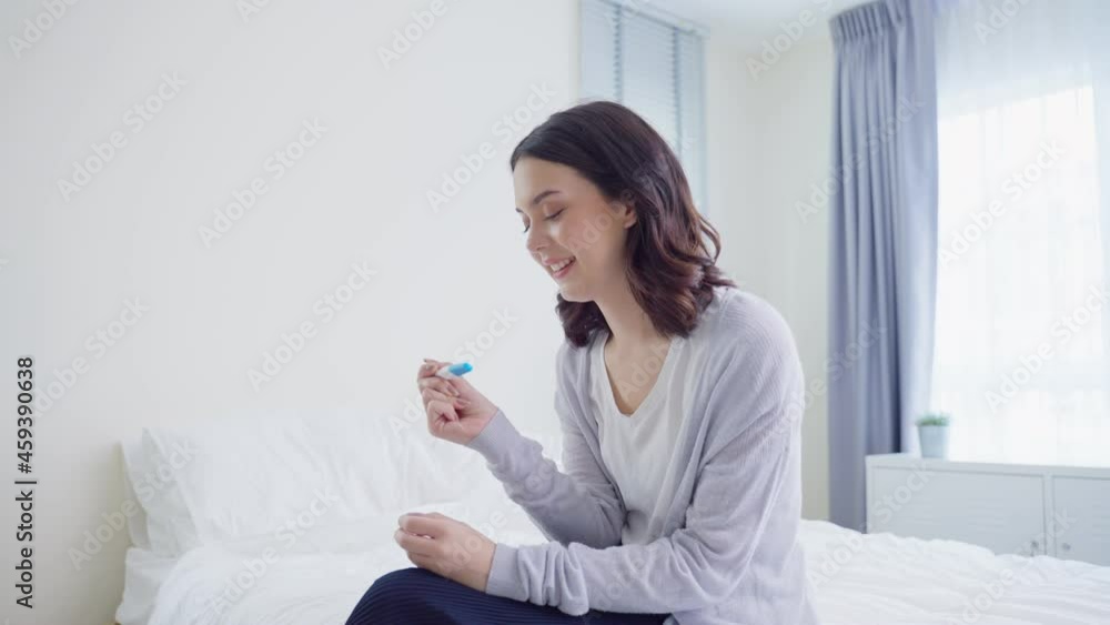 Asian young woman feeling happy after look at positive pregnancy test. Asian young woman feeling happy after look at positive pregnancy test.