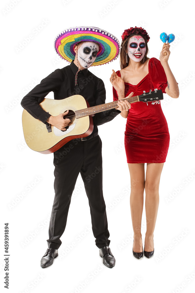 Young couple with painted skull on faces, guitar and maracas against white background. Celebration of Mexico's Day of the Dead (El Dia de Muertos) Young couple with painted skull on faces, guitar and maracas against white background. Celebration of Mexico's Day of the Dead (El Dia de Muertos)