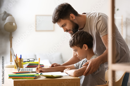 Little boy with his father doing lessons at home © Pixel-Shot