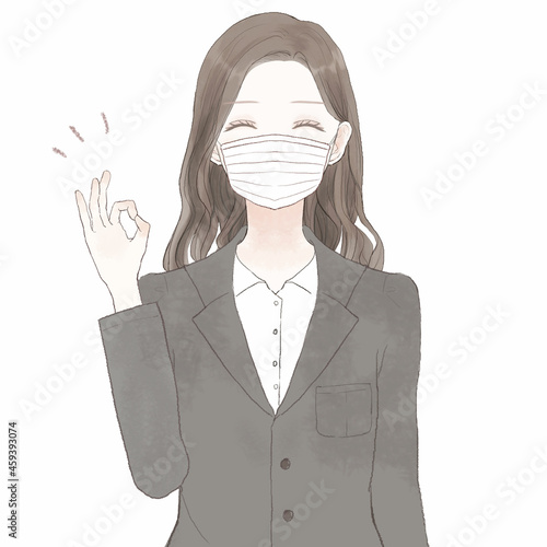 OKサインを出す、不織布マスクを着用したスーツを着た女性