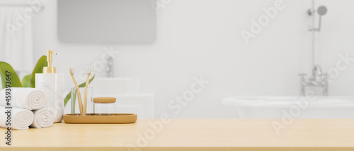 Fotografia Wooden board or tabletop with mockup space and bath accessories over modern whit