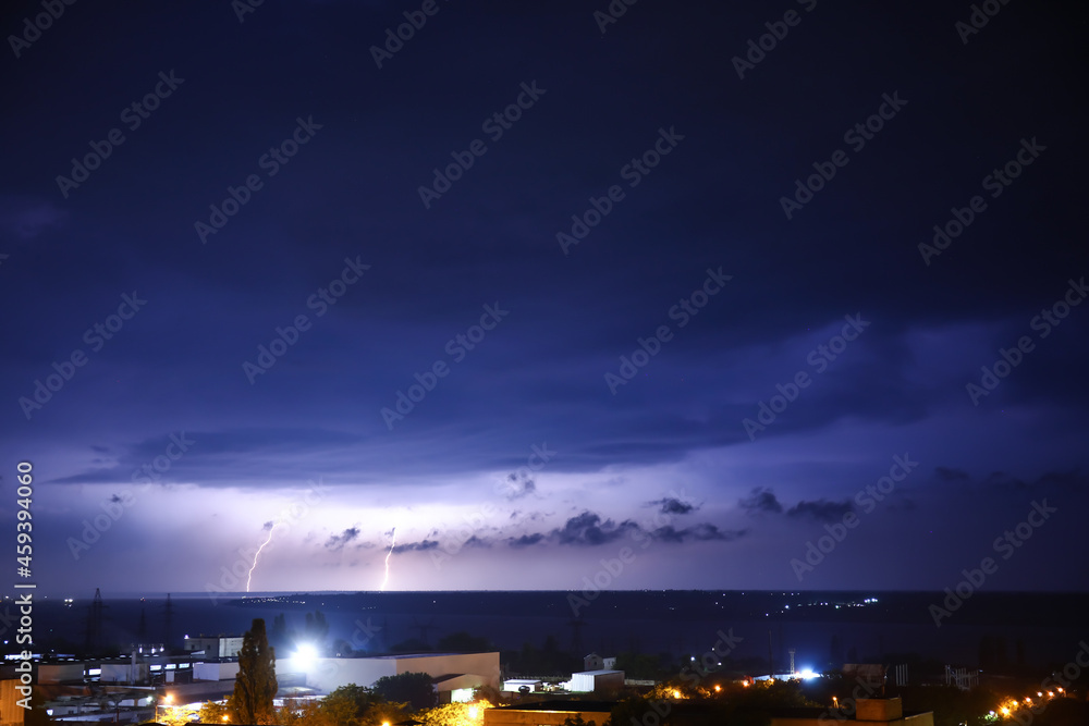 Dark sky with lightning over city