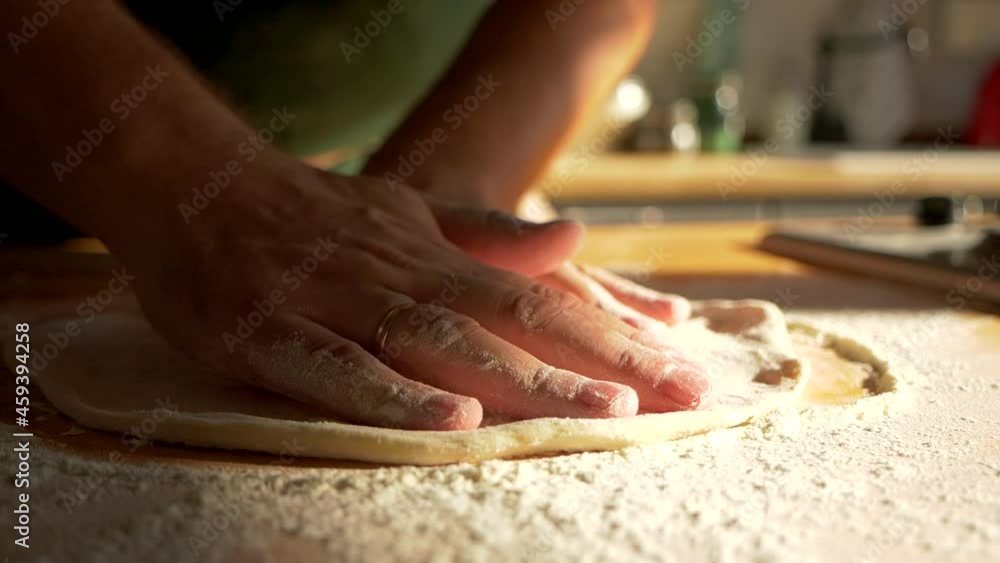 Close up macro shots of Italian bakery food restaurant kitchen. Chef cook knead future piece of pizza, forms the dough, demonstration of pastry stretching. Pizza form preparation. Professional cuisine Close up macro shots of Italian bakery food restaurant kitchen. Chef cook knead future piece of pizza, forms the dough, demonstration of pastry stretching. Pizza form preparation. Professional cuisine