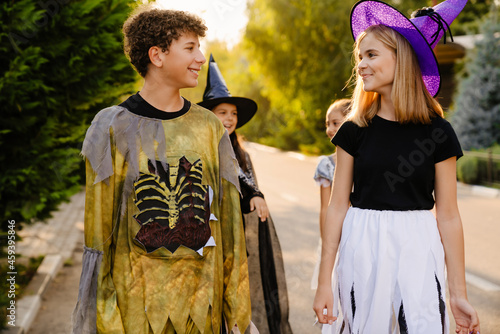 White children smiling while going trick-or-treating during Halloween