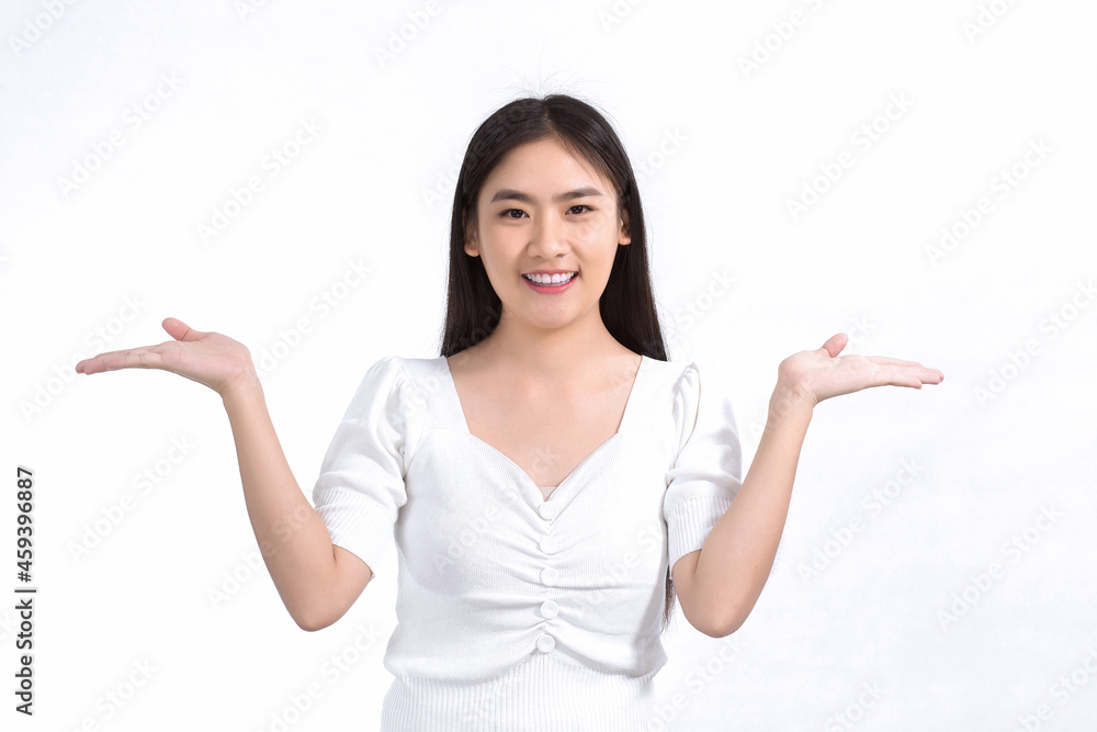 Asian girl in black long hair wears white shirt and shows point up to present something on white background. Asian girl in black long hair wears white shirt and shows point up to present something on white background.