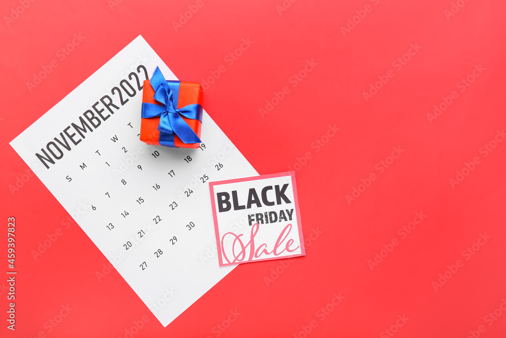 Calendar page of November 2022 and gift on color background. Black Friday Calendar page of November 2022 and gift on color background. Black Friday