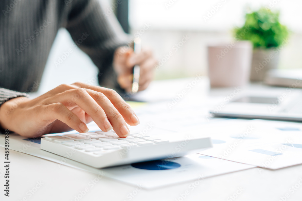 Fototapeta premium Close up view of bookkeeper or financial inspector hands making report, calculating or checking balance. Home finances, investment, economy, saving money or insurance concept.