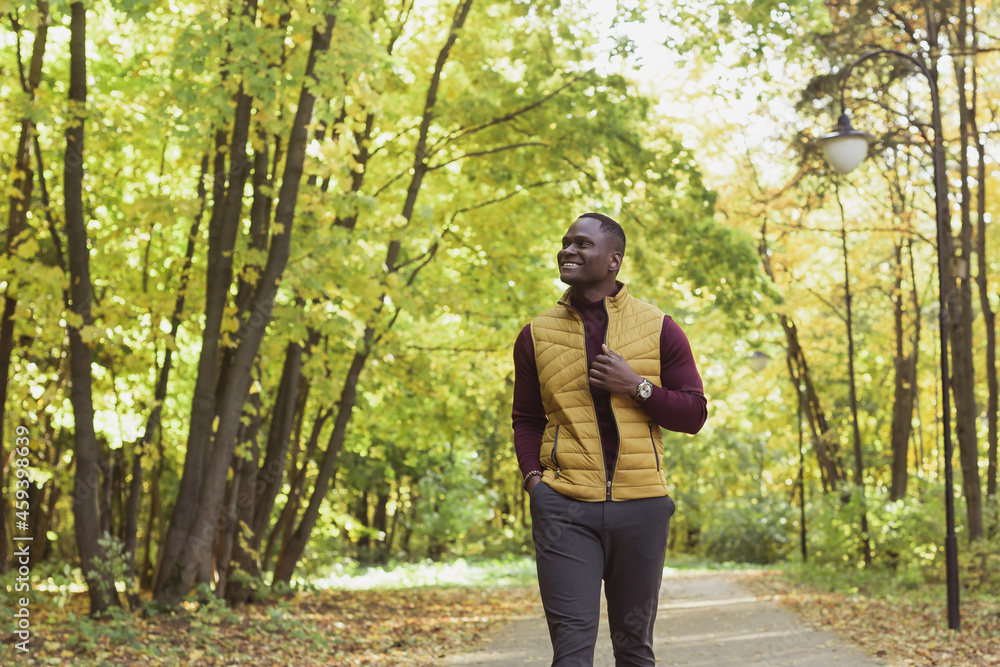 Male student walking in the park in autumn season