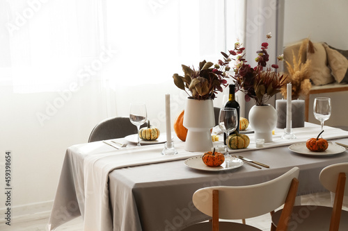 Beautiful autumn table setting with flowers and pumpkins at restaurant