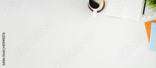 Top view coffee cup, houseplant and empty notebook on white table. Copy space.