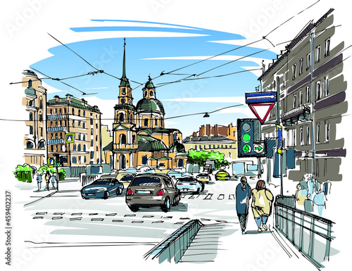 Busy road with cars and sidewalk with pedestrians in town center