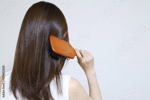 髪の毛をブラッシングする女性