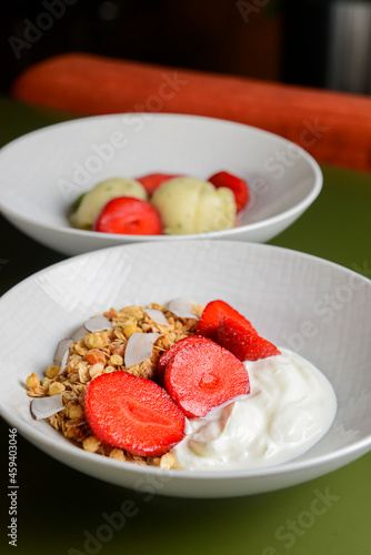 Fototapeta Naklejka Na Ścianę i Meble -  Bowl of hot oatmeal with fresh strawberries cut. Perfect as a healthy breakfast. Served with sour cream in a white bowl.