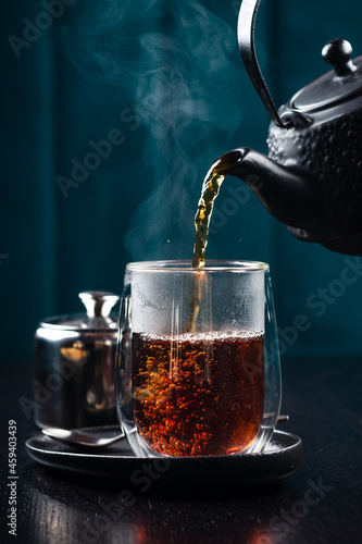 Obraz na płótnie hot tea is poured into a glass with steam