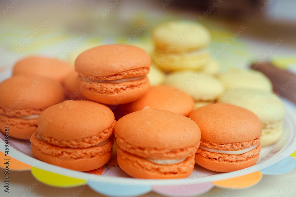 Close-up of a plate of orange and yellow french macarons Close-up of a plate of orange and yellow french macarons