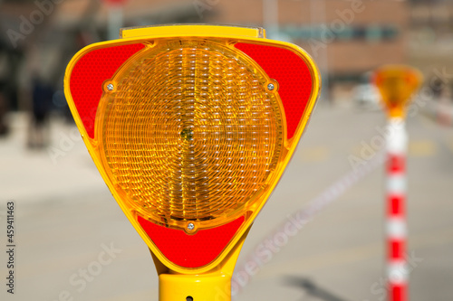 Close-up of a triangle-shaped flasher traffic warning light, which is positioned to ensure traffic safety.