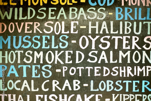 Hand painted sign listing seafood items photo