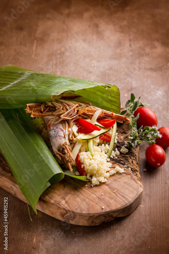 shrimp coucous with zucchinis cooked on banana leaf photo