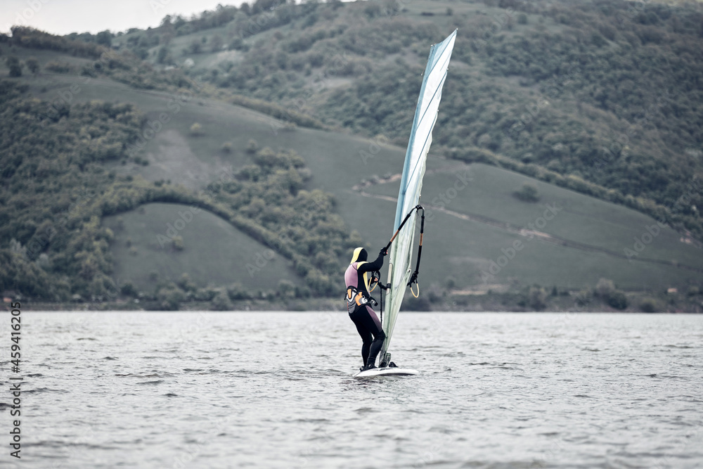 Naklejka premium Windsurfer surfing on a windy day at the river.