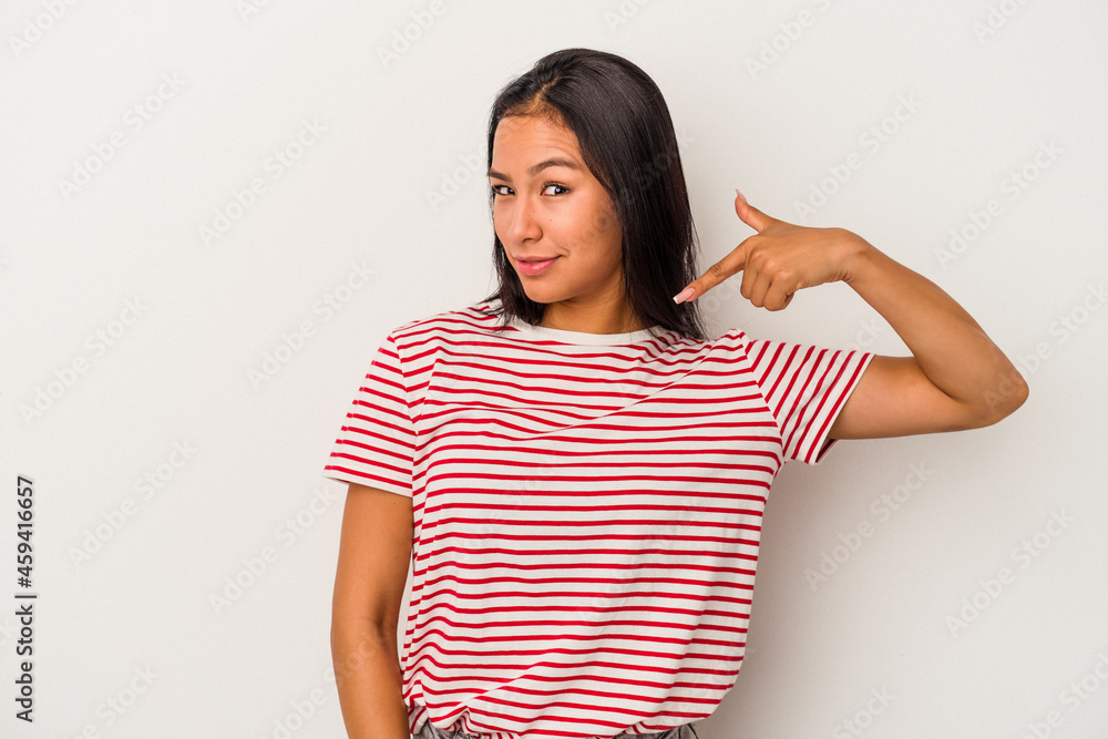 Young latin woman isolated on white background person pointing by hand to a shirt copy space, proud and confident Young latin woman isolated on white background person pointing by hand to a shirt copy space, proud and confident