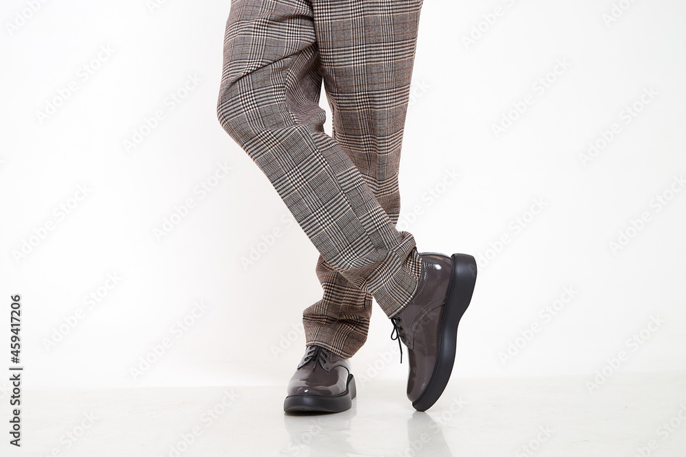Brown female or male patent leather shoes on legs of woman. Shooting for a catalog or an online store. A pair of shoes Brown female or male patent leather shoes on legs of woman. Shooting for a catalog or an online store. A pair of shoes