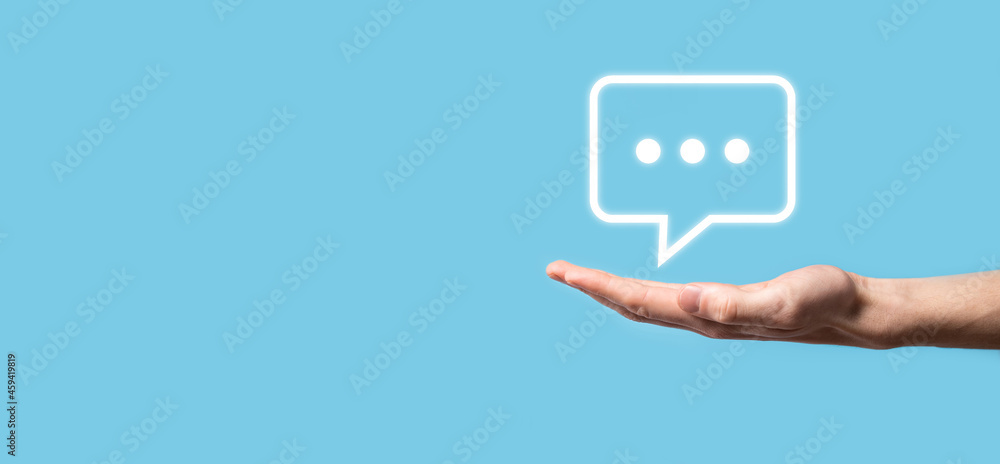 Businessman holding a message icon, bubble talk notification sign in his hands. Chat icon, sms icon, comments icon, speech bubbles