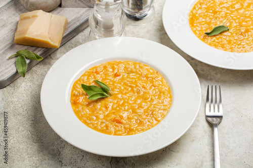 Foto Risotto with pumpkin and taleggio cheese, decorated with sage leaves